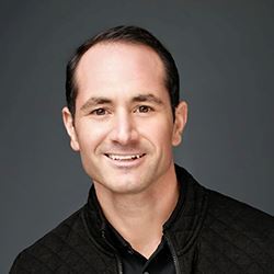 Headshot of Anthony Larijani wearing a button up shirt and blazer smiling