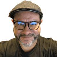 Headshot of Willy Ortiz wearing a hat and smiling